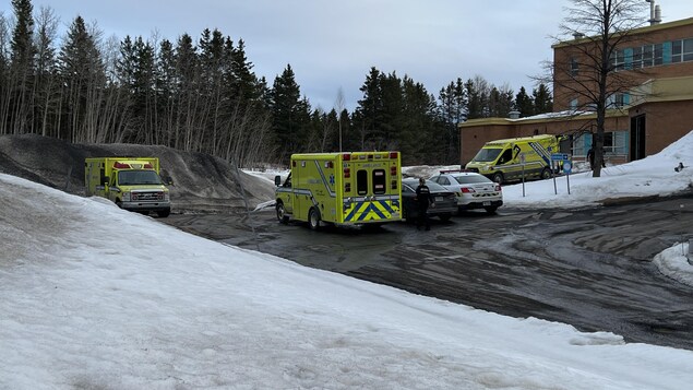 Trois ambulances sont dans le stationnement sur le côté de l'hôpital d'Amqui, l'hiver.