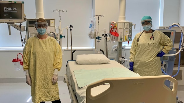 Deux infirmières de chaque côtés d'un lit d'hôpital.