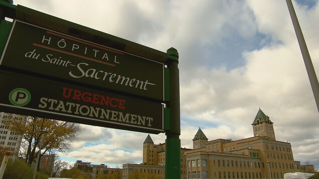 Vue extérieure de l'Hôpital du Saint-Sacrement et de l'affiche de l'entrée à l'urgence.