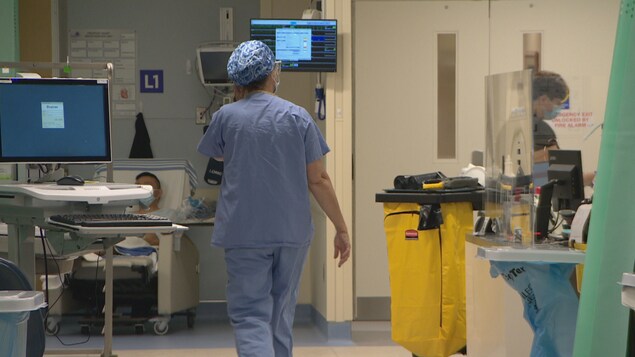 Une infirmière marche dans une aile à l'hôpital.