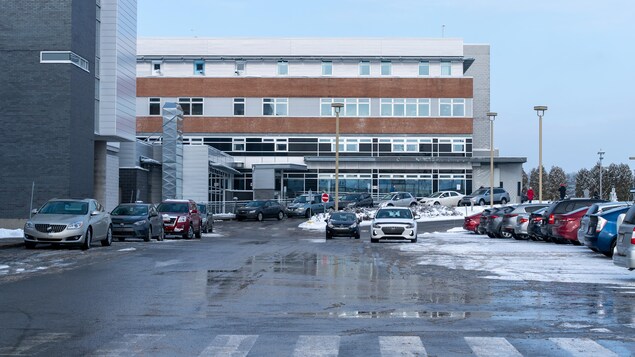 L'extérieur de l'hôpital et des voitures dans le stationnement, en hiver.