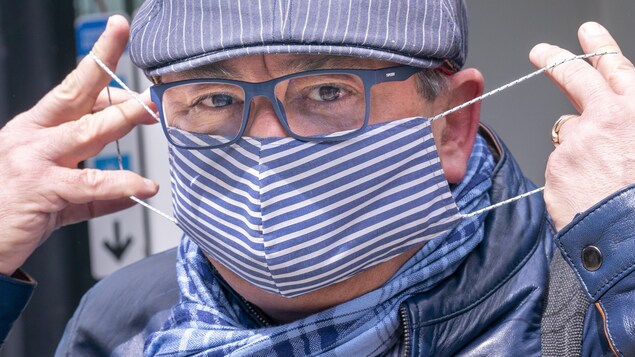 Le Dr Horacio Arruda mettant un masque en tissu.