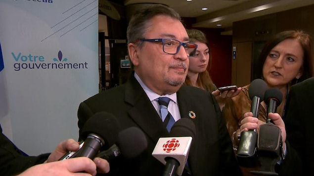 Dr Horacio Arruda entouré de journalistes en point de presse.