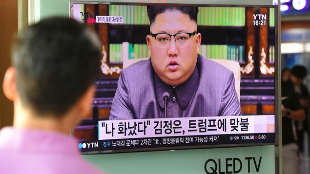 Un Nord-Coréen de dos regarde un écran de télévision sur lequel on voit Kim Jong-un. Un Nord-Coréen de dos regarde un écran de télévision sur lequel on voit Kim Jong-un.