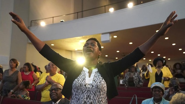 Une femme lève les bras au ciel pendant que le pasteur Jesse Jackson prononce son éloge funèbre lors de l'office à la mémoire d'Aretha Franklin. Une femme lève les bras au ciel pendant que le pasteur Jesse Jackson prononce son éloge funèbre lors de l'office à la mémoire d'Aretha Franklin.
