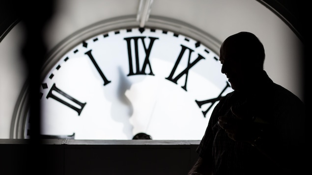 L'horloger André Viger est photographié à contre-jour, dans la tour-horloge de l'Assemblée nationale du Québec.