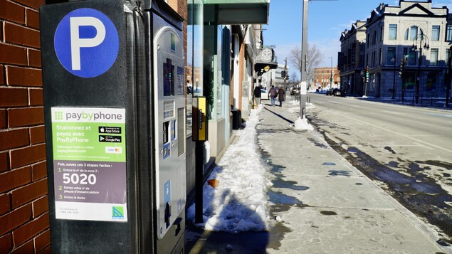 Horodateur sur rue l'hiver.