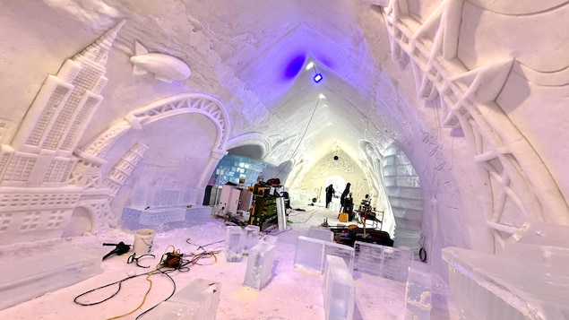 Des outils traînent au milieu d'un grand hall intérieur de neige et de glace.