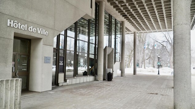 Façade de l’hôtel de ville de Trois-Rivières en hiver. Inscription «hôtel de ville» au-dessus de la porte.