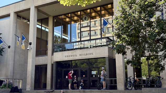 Des passants sont devant l'hôtel de ville de Winnipeg