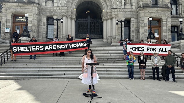 Des personnes avec des banderoles pour le droit au logement, devant l'Assemblée législative, à Victoria, le 7 mai 2024.