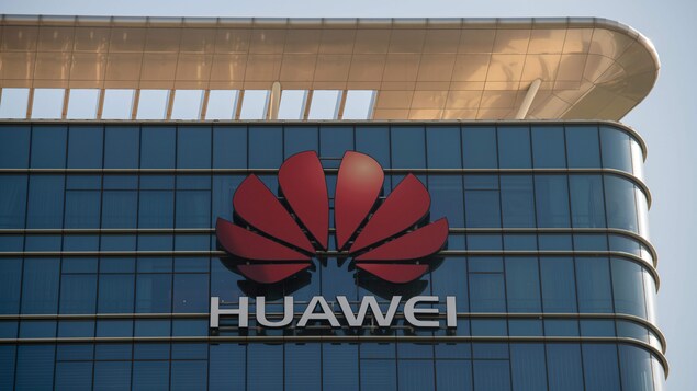 Gros plan sur le logo de Huawei sur la façade d'un gratte-ciel vitré.
