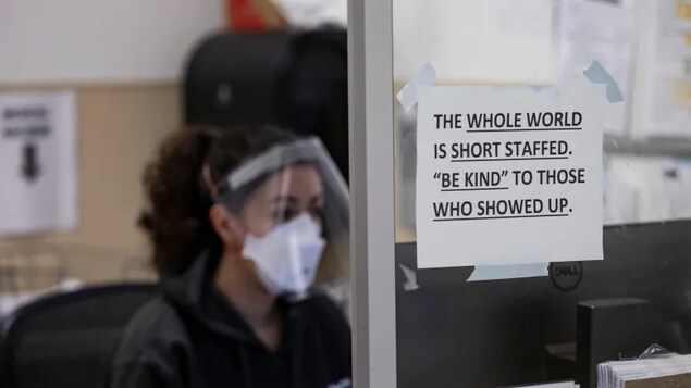 A nurse sits behind a sign in the Humber River Hospital emergency department in Toronto on Jan. 13. Days after the province's top doctor said Ontario might see up to 600 patients in intensive care during the ongoing sixth wave, hospitals say they're already feeling pressure as a result of staff absences due to the virus. (Evan Mitsui/CBC)