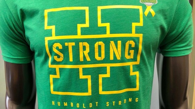 Un t-shirt avec en gros la lettre H, sur laquelle il est écrit le mot « strong ». Un t-shirt avec en gros la lettre H, sur laquelle il est écrit le mot « strong ».