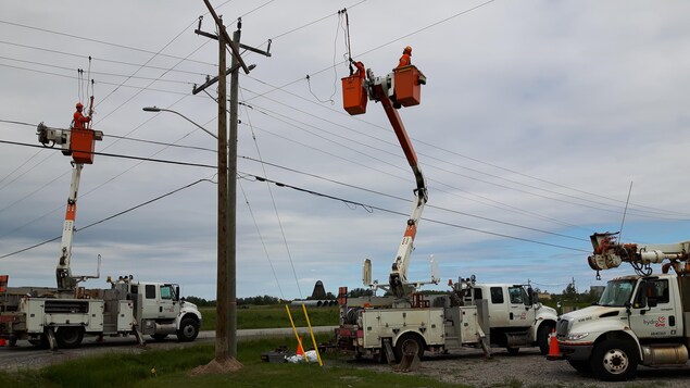 Des employés d'Hydro One effectuent des travaux sur une ligne de transmission électrique.