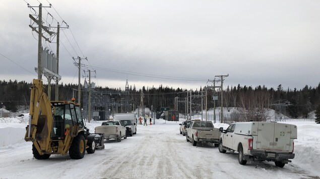 Des employés et des camions d'Hydro-Québec devant la sous-station de Rivière-Pentecôte.
