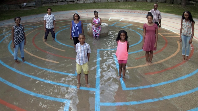 9 membres d'une famille dans un parc autour d'une fontaine.