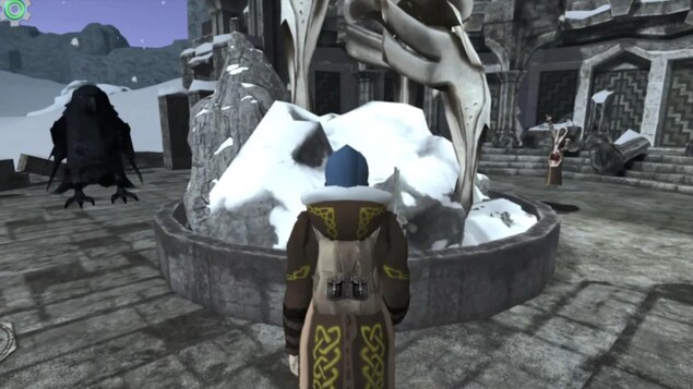Un personnage dans un jeu vidéo marche sur de la pierre grise et fait face à une sculpture avec un corbeau au loin.