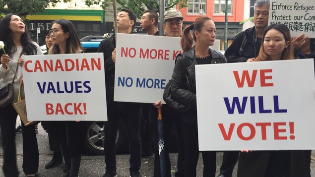Une dizaine de personnes avec des affiches où on peut lire Canadian values back, we will vote! Une dizaine de personnes avec des affiches où on peut lire Canadian values back, we will vote!