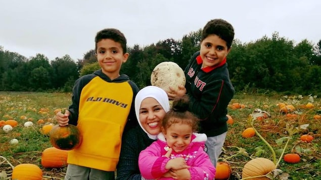 Ikram Khaouani et ses trois enfants dans un champ de citrouille.
