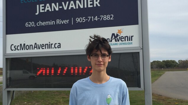 Photo d'Ilann devant le panneau de l'école Photo d'Ilann devant le panneau de l'école