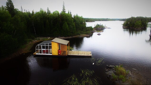 L'Îloft flotte sur le lac, à proximité des berges.