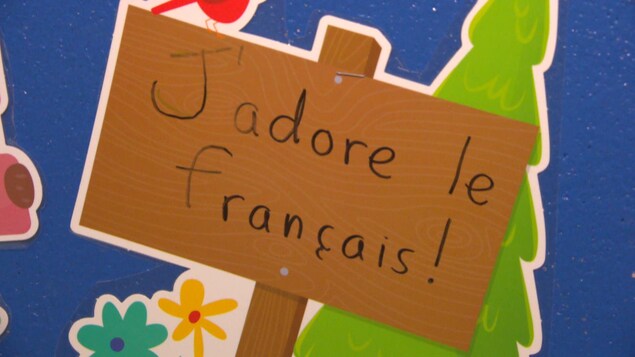 Une affiche faite par un enfant sur laquelle il est écrit : J'adore le français.