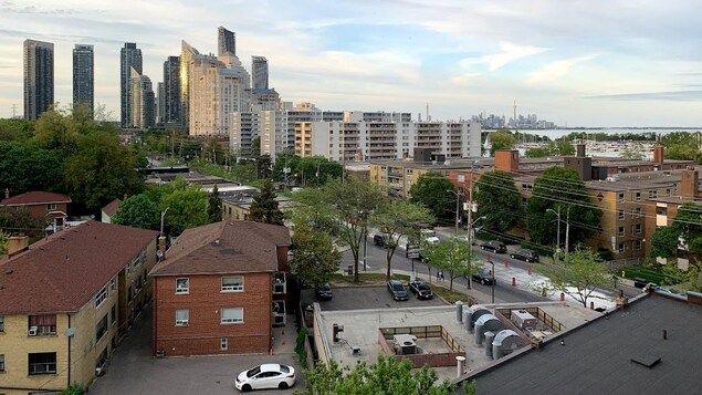 Des immeubles de quatre étages et moins apparaissent au premier plan de la photo, puis des tours d'habitation et, au loin, la ville de Toronto.