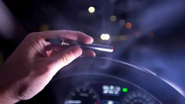 Smoke from a cannabis oil vaporizer rises behind the wheel of a car. A third of respondents who'd smoked cannabis within the last year reported in a recent survey that they'd driven while under the influence of the drug. (THE CANADIAN PRESS /Jonathan Hayward)