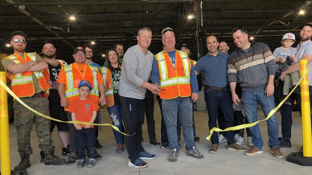 Le maire de Sept-Îles coupe de ruban d'inauguration du nouveau hangar de la Ville en compagnie de l'équipe des travaux publics.