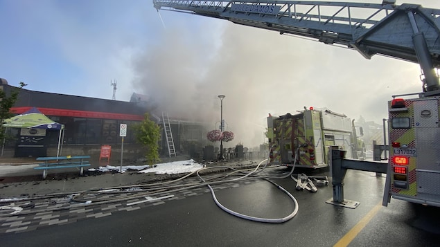 Des camons de pompiers devant un immeuble incendié