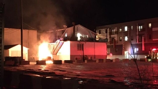 Un incendie dans un véhicule dans une ruelle derrière un bloc à logements.