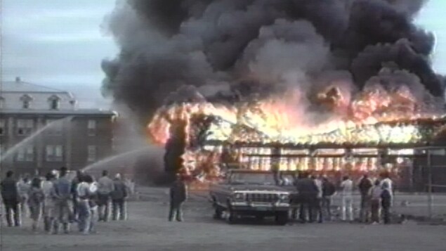 Une image d'archives des flammes qui ont ravagé le Collège Mathieu en 1988. On y voit des gens qui arrosent le feu ainsi que les flammes et la fumée épaisse qui s'en dégage. Une image d'archives des flammes qui ont ravagé le Collège Mathieu en 1988. On y voit des gens qui arrosent le feu ainsi que les flammes et la fumée épaisse qui s'en dégage.