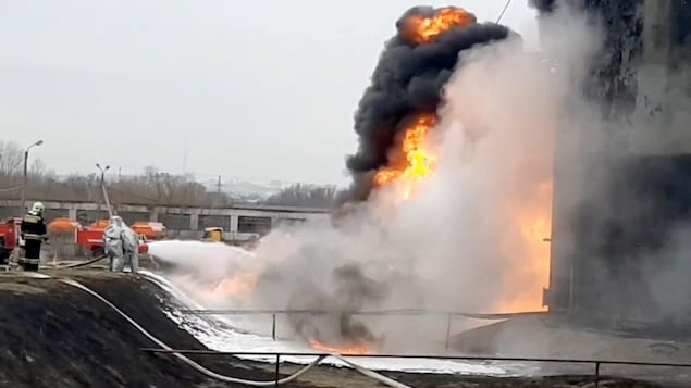 A still image taken from video footage shows members of the Russian Emergencies Ministry extinguishing a fire at a fuel depot in the city of Belgorod on Friday.