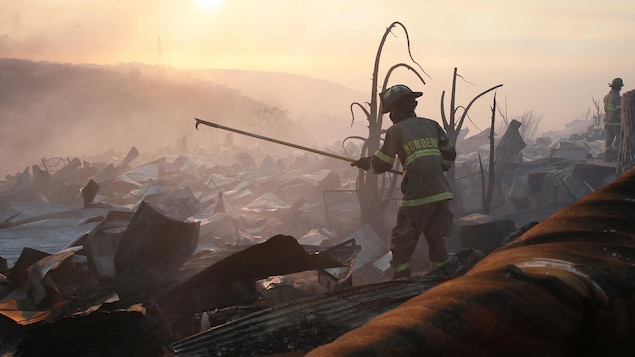 Un pompier se place au coeur des décombres d'un important incendie de forêt au Chili.