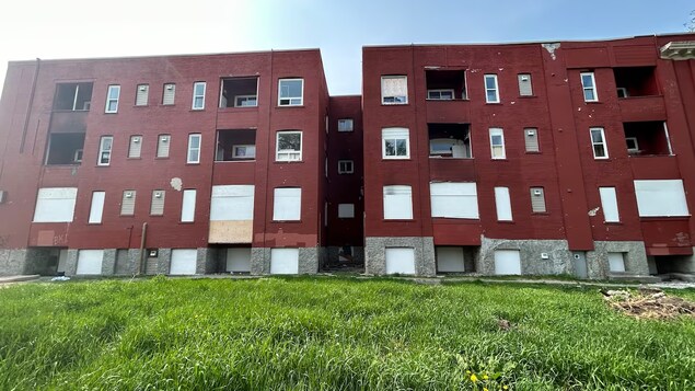 Un bâtiment à appartements dont plusieurs portes et fenêtres sont barricadées.