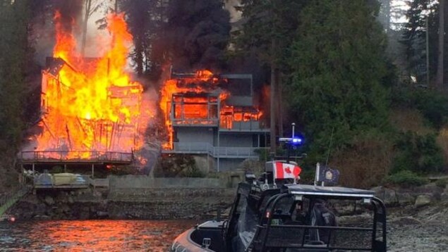 Deux maisons en train de brûler dans la communauté de Belcarra, dans le district régional du Grand Vancouver.