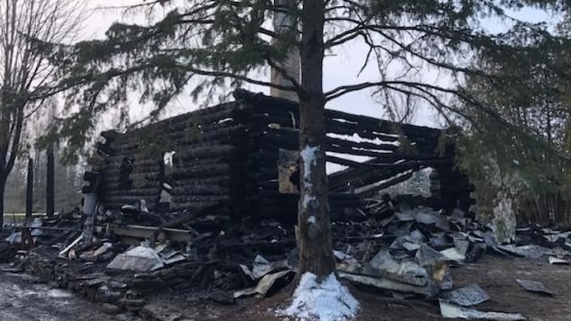 Une maison en rondins des bois ravagée par les flammes.