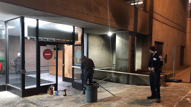 Un gardien de sécurité supervise le nettoyage devant le palais de justice de Gatineau.