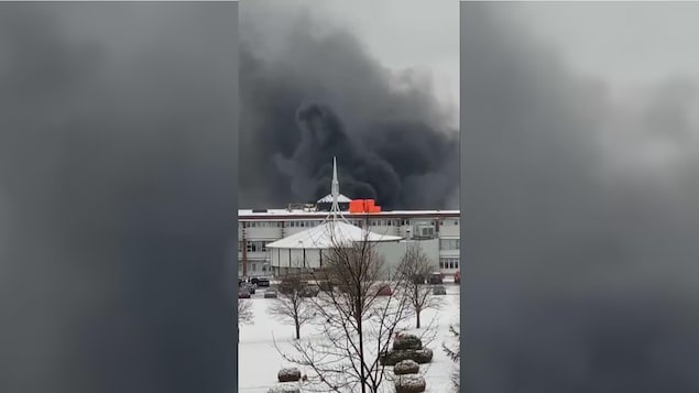 Un épais panache de fumée s'élève au-dessus d'un bâtiment du Séminaire St-François.
