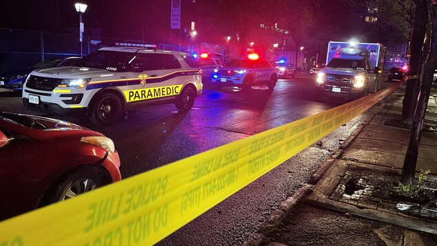 Une voiture des paramedics d'Ottawa, une ambulance et une voiture de police, leurs gyrophares sont allumés. Une bande de la police ferme un secteur à cause d'un incident.