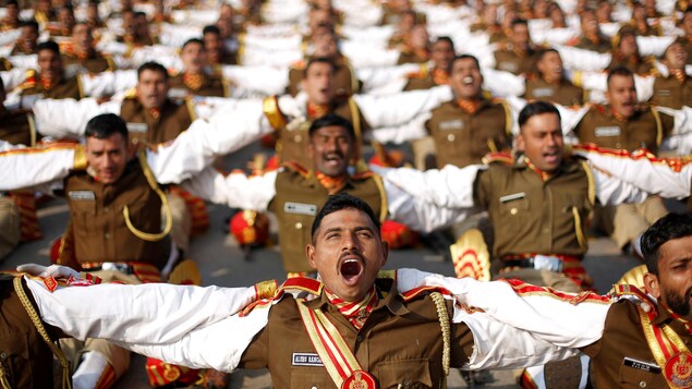Des soldats indiens se tenant par les épaules rient lors d'une séance de yoga. Des soldats indiens se tenant par les épaules rient lors d'une séance de yoga.