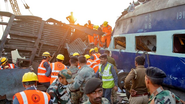 Les services de secours tentent de retrouver des survivants sur le site d'un déraillement de train à Pukhrayan, en Inde.