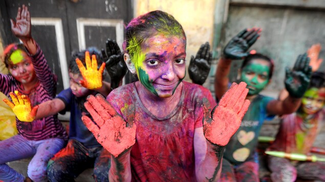 Une fillette peinte de diverses couleurs montre ses paumes Une fillette peinte de diverses couleurs montre ses paumes