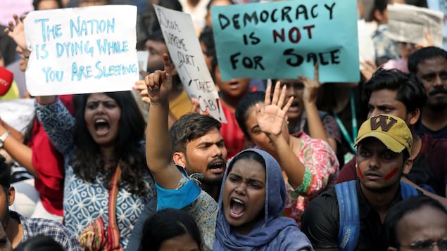 Hommes et femmes manifestent en criant des slogans à Delhi.