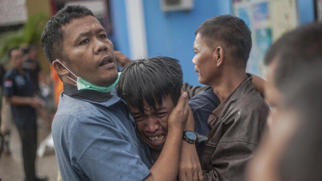 Un homme pleure après avoir identifié un proche tué par un tsunami.
