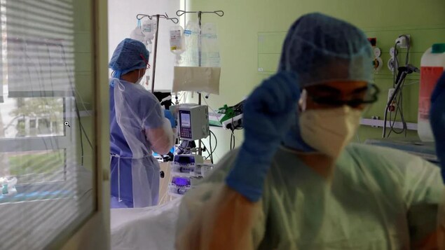 Deux infirmières en habits de protection dans un hôpital.