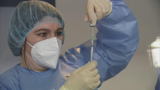 Une infirmière prépare un vaccin contre la COVID-19.