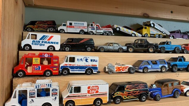 Various dinkies on wooden shelves.