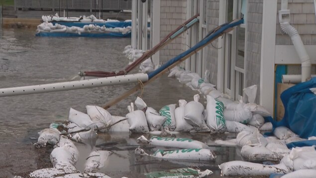 Des sacs de sable empilés le long de la fondation d'une maison inondée. Des sacs de sable empilés le long de la fondation d'une maison inondée.